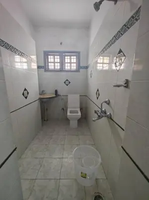 a small bathroom with a toilet and a window at Waterfall Villa - 4BHK in Mysore