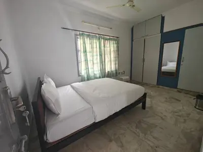 a bedroom with a large white bed with a window at Waterfall Villa - 4BHK in Mysore