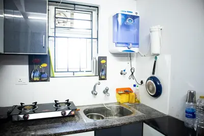 a kitchen with a sink and a stove and a window at Elite Dharshan H5 - AC 2 BHK Apartment near Guruvayur Temple in Guruvāyūr