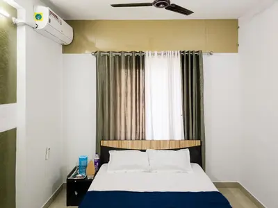 a bedroom with a bed and a window at Elite Dharshan H5 - AC 2 BHK Apartment near Guruvayur Temple in Guruvāyūr