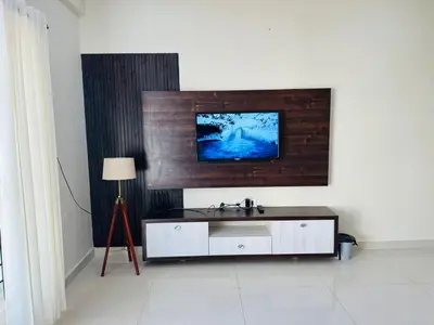 a bathroom with a sink and a tv on a wall at Oryx Hotel Apartments in Mysore