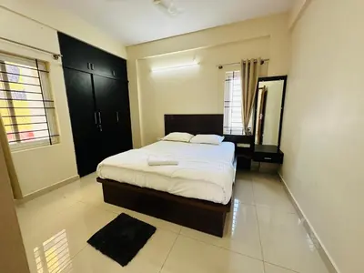 a bedroom with a bed and a mirror in it at Oryx Hotel Apartments in Mysore