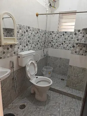 a bathroom with a toilet and a shower at Downtown Service Apartments in Mysore