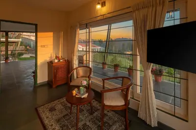 a living room with a large window and a tv at Solitude by Nature Resorts and Stays in Kotagiri