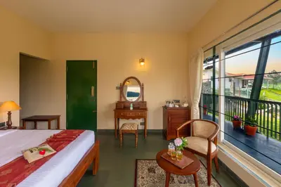 a bedroom with a bed and a large window at Solitude by Nature Resorts and Stays in Kotagiri