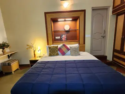 a bedroom with a large blue bed in a room at Golden castle in Mysore