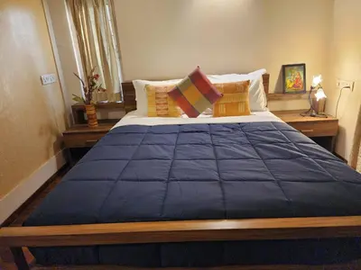 a bedroom with a large blue bed with pillows at Golden castle in Mysore