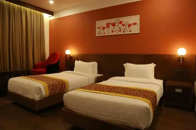 a hotel room with two beds and a red wall at SKY PENTA RESIDENCY in Iritti