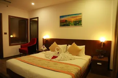 a bedroom with a bed and a red chair at SKY PENTA RESIDENCY in Iritti