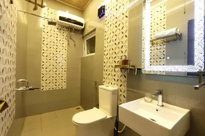 a bathroom with a white toilet and a sink at Green Wood Hill Cottage in Ooty