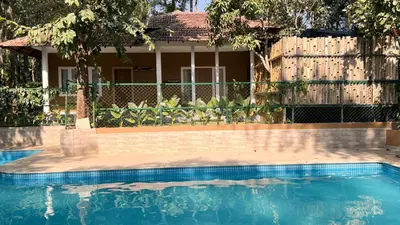 a house with a swimming pool in front of a fence at Mystery Maze Resort and Spa in Wayanad