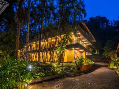 a house with a bunch of plants in front of it at The Hosteller Wayanad, Vythiri in Vythiri