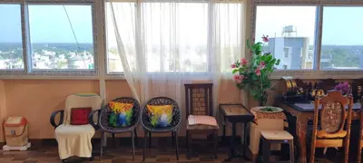 a group of chairs in a room with windows at Vrindavan - An Artists Nook in Mysore