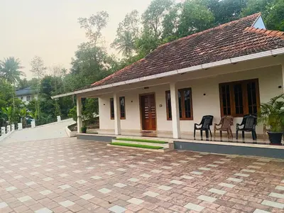 a small house with a brick patio in front of it at HappyDays HomeStay Wayanad in Chekadi