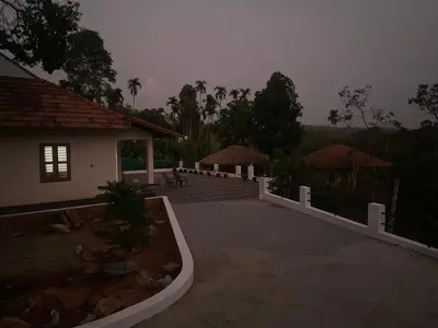 a house with a white fence and a patio at HappyDays HomeStay Wayanad in Chekadi