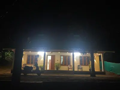 a house with a person walking in front of it at night at HappyDays HomeStay Wayanad in Chekadi