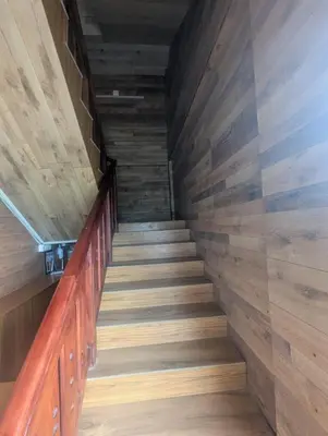 a staircase in a house with wood paneling at Mountain Mist Meadows in Ooty