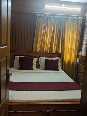 a bedroom with a large bed with curtains at Mountain Mist Meadows in Ooty