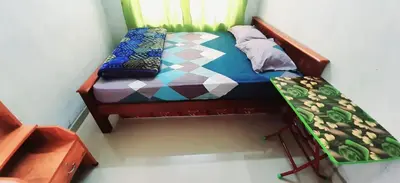 a small bed in a room with a window at Hiya Holidays in Munnar