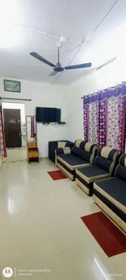 a living room with couches and a flat screen tv at Hiya Holidays in Munnar