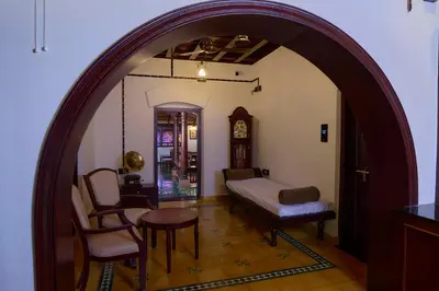 a room with an archway with a bed and a clock at Malabar Kovilakam in Malappuram