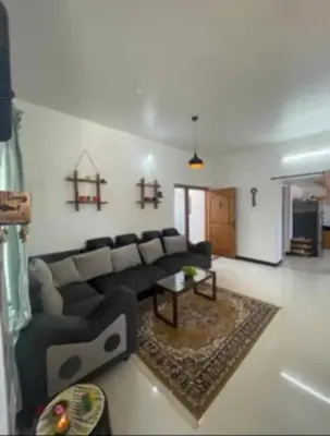 a living room with a couch and a table at White House Kotagiri, 2bhk in Kotagiri