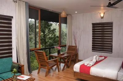 a bedroom with a bed and a balcony with a table and chairs at TREE6 WAYANAD in Vythiri