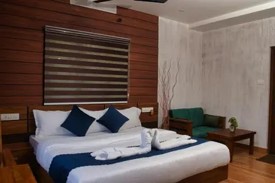 a bedroom with a bed and a green chair at TREE6 WAYANAD in Vythiri