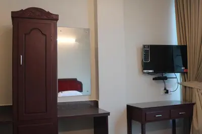 a room with a cabinet and a television on a wall at LILLY RESIDENCY by Chungath in Perumbavoor