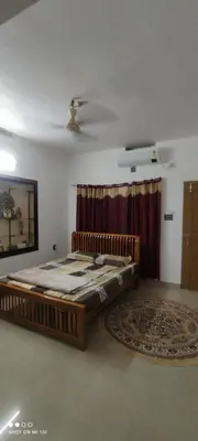 a large bed in a room with a rug at Vyshnavi Home stay in Thanniyam