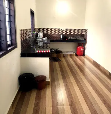 a kitchen with a counter and a wooden floor at Vythiri Garden in Vythiri