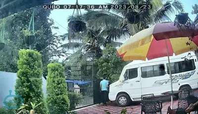 a man standing next to a white van with an umbrella at Vythiri Garden in Vythiri