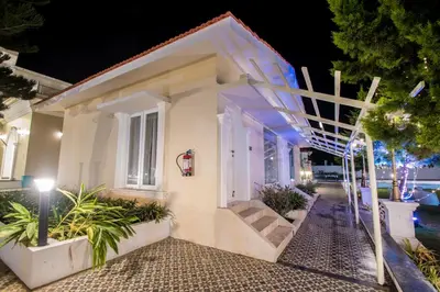 a white house with a staircase in front of it at CSR Landmark Resorts in Coimbatore