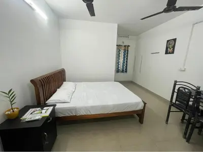 a bedroom with a bed and a table with a desk at Vyshnavi home stay in Thanniyam