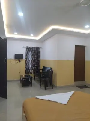 a bedroom with a bed and a table and chairs at Lotus Grand Residency in Angādipuram