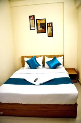 a bedroom with a large bed with blue pillows at MARHABA PALACE in Kozhikode
