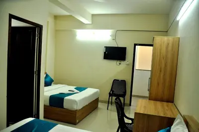 a bedroom with a bed and a desk and a chair at MARHABA PALACE in Kozhikode
