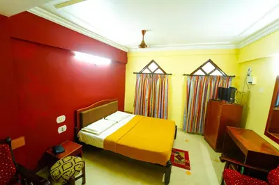 a bedroom with a bed in a room with red walls at AMOGHA RESIDENCY in Mysore