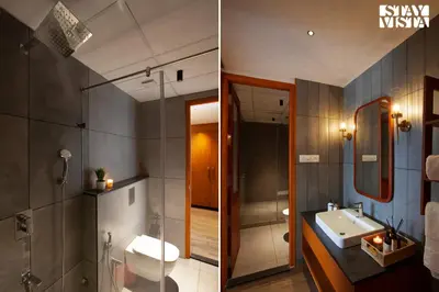 a bathroom with a sink and a toilet and a mirror at Rivera The Lake View with Indoor Games by StayVista in Wayanad