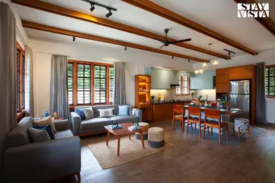 a living room with a couch and a table at Rivera The Lake View with Indoor Games by StayVista in Wayanad