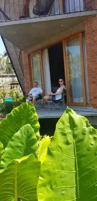 two people sitting in chairs on the porch of a house at Bimal's Casa de Papel in Kadikkād