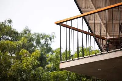 a balcony of a building with trees in the background at Bimal's Casa de Papel in Kadikkād