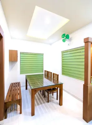 a dining room with a table and benches at Wayanad Valentine Pool Resort in Sultan Bathery