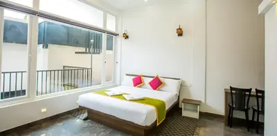 a bedroom with a bed and a large window at Wayanad Valentine Pool Resort in Sultan Bathery