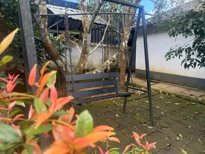 an empty swing in a garden with flowers at Empire Private Pool Villa in Kalpetta