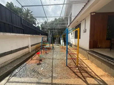 a group of playground equipment in front of a building at Empire Private Pool Villa in Kalpetta