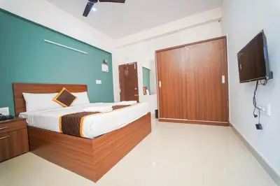 a bedroom with a large bed and a tv in it at AYANI INN in Mysore