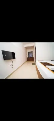 a white room with a flat screen tv on a wall at AYANI INN in Mysore