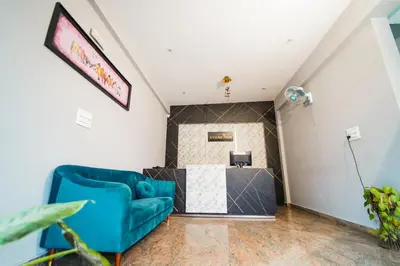 a living room with a blue couch and a table at AYANI INN in Mysore