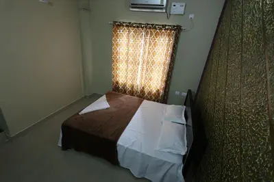 a bedroom with a bed and a window with a curtain at Wayanad regal residency in Kalpetta